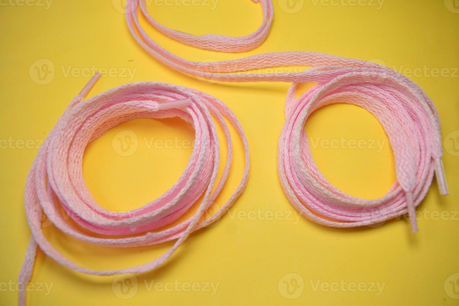 pink shoelaces on a yellow background photo