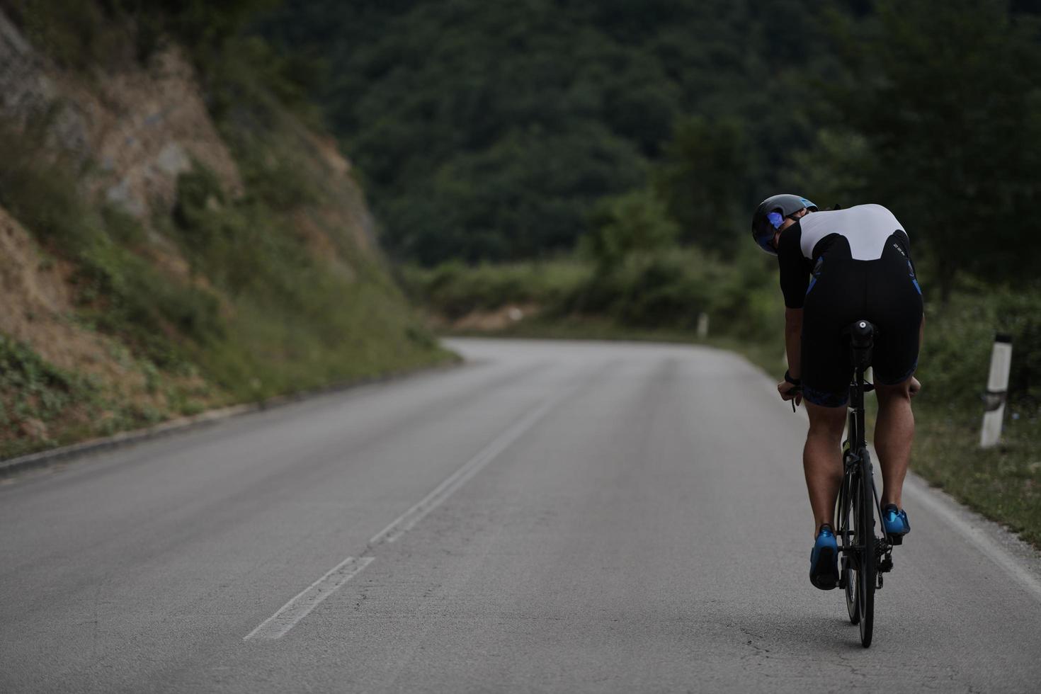 triathlon athlete riding a bike wearing black photo