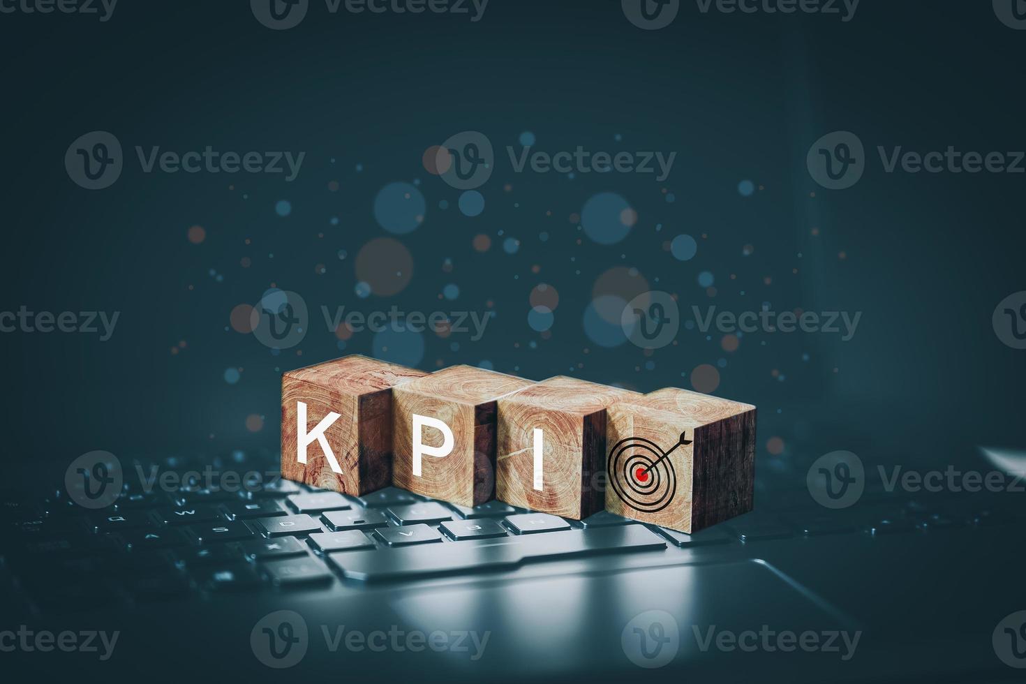 KPI word on wooden cube block which is placed on a laptop. Business growth and goal in next year concept. photo