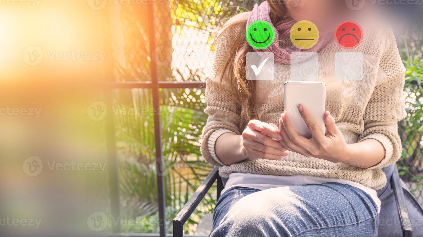 Adult woman using a smartphone in give rating to service experience on application. Online customer review satisfaction feedback survey. photo