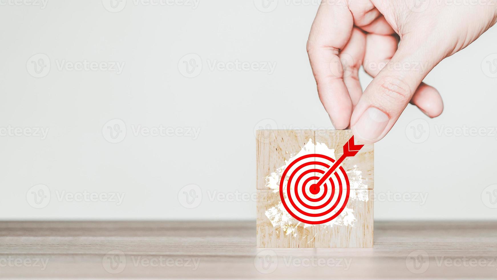 Hand put a goal icon on wooden cubes block on wood table. Business growth and goal in next year concept photo