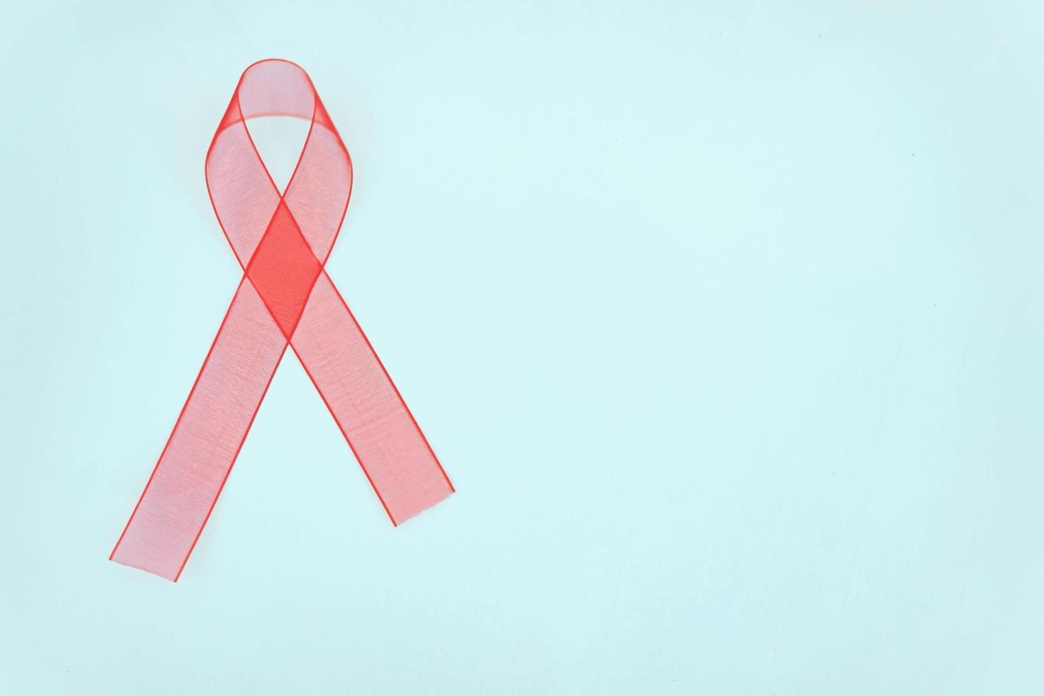 Closeup red ribbon awareness on White background for World Aids day campaign. Healthcare and medicine concept. photo