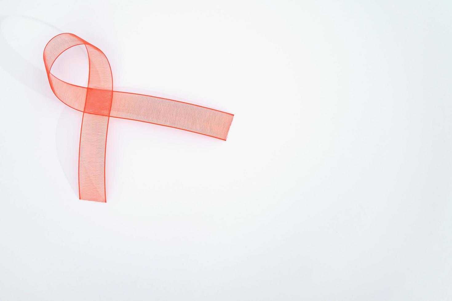 Closeup red ribbon awareness on White background for World Aids day campaign. Healthcare and medicine concept. photo