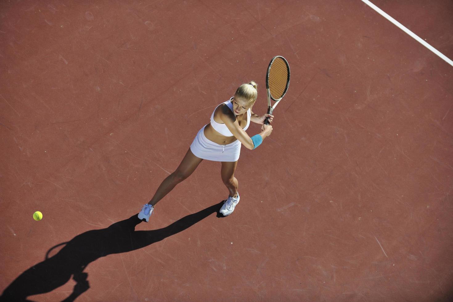 mujer joven jugar al tenis al aire libre foto