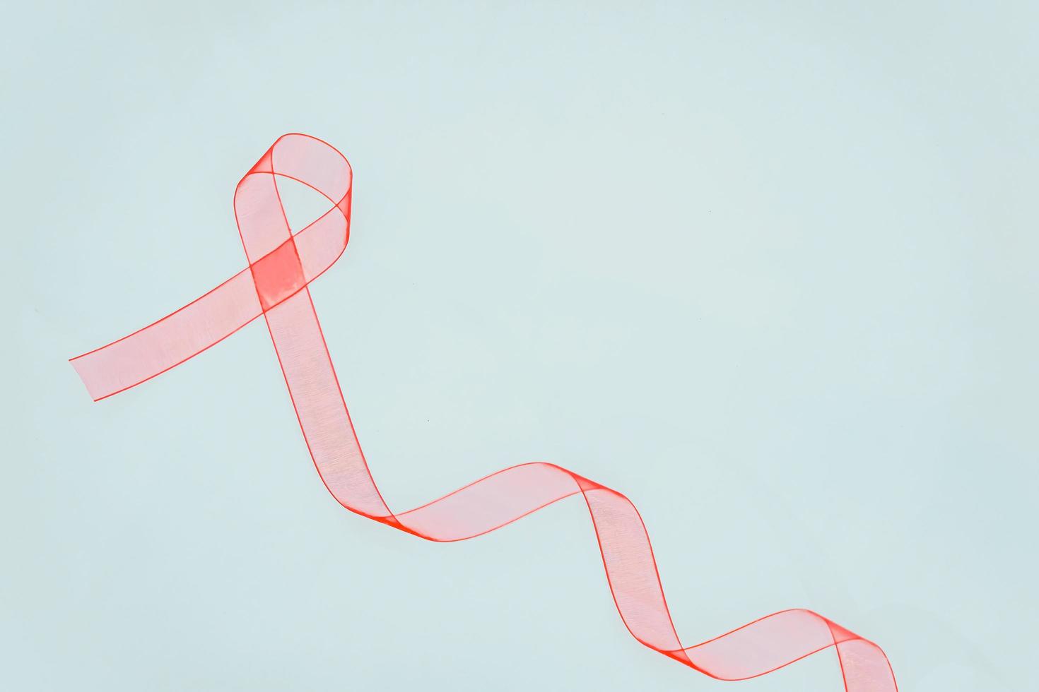 Closeup red ribbon awareness on White background for World Aids day campaign. Healthcare and medicine concept. photo