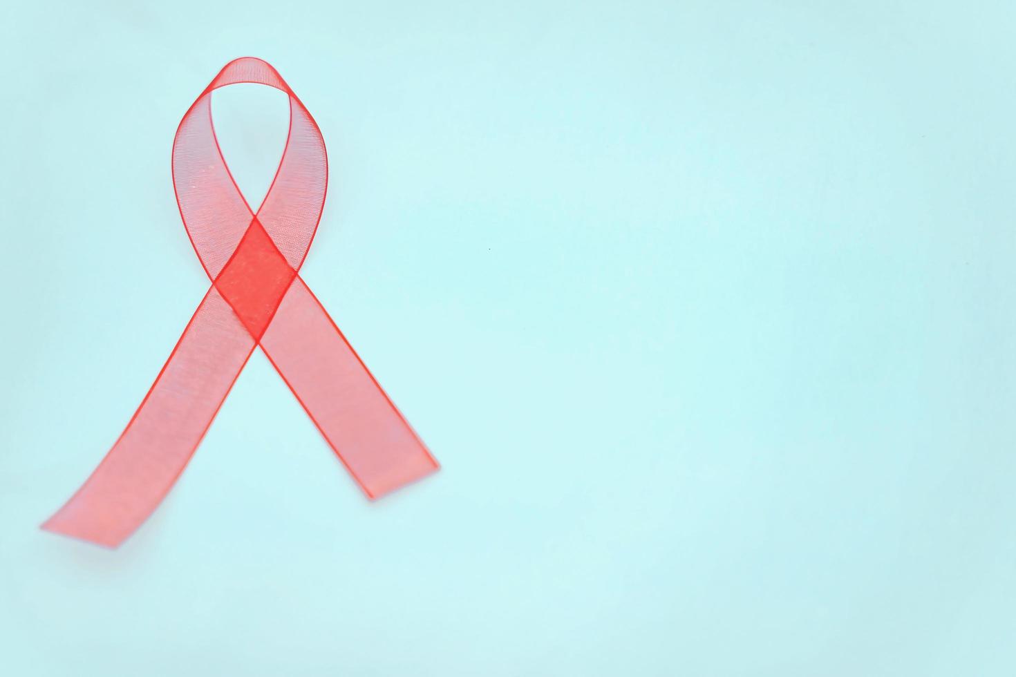 Closeup red ribbon awareness on White background for World Aids day campaign. Healthcare and medicine concept. photo