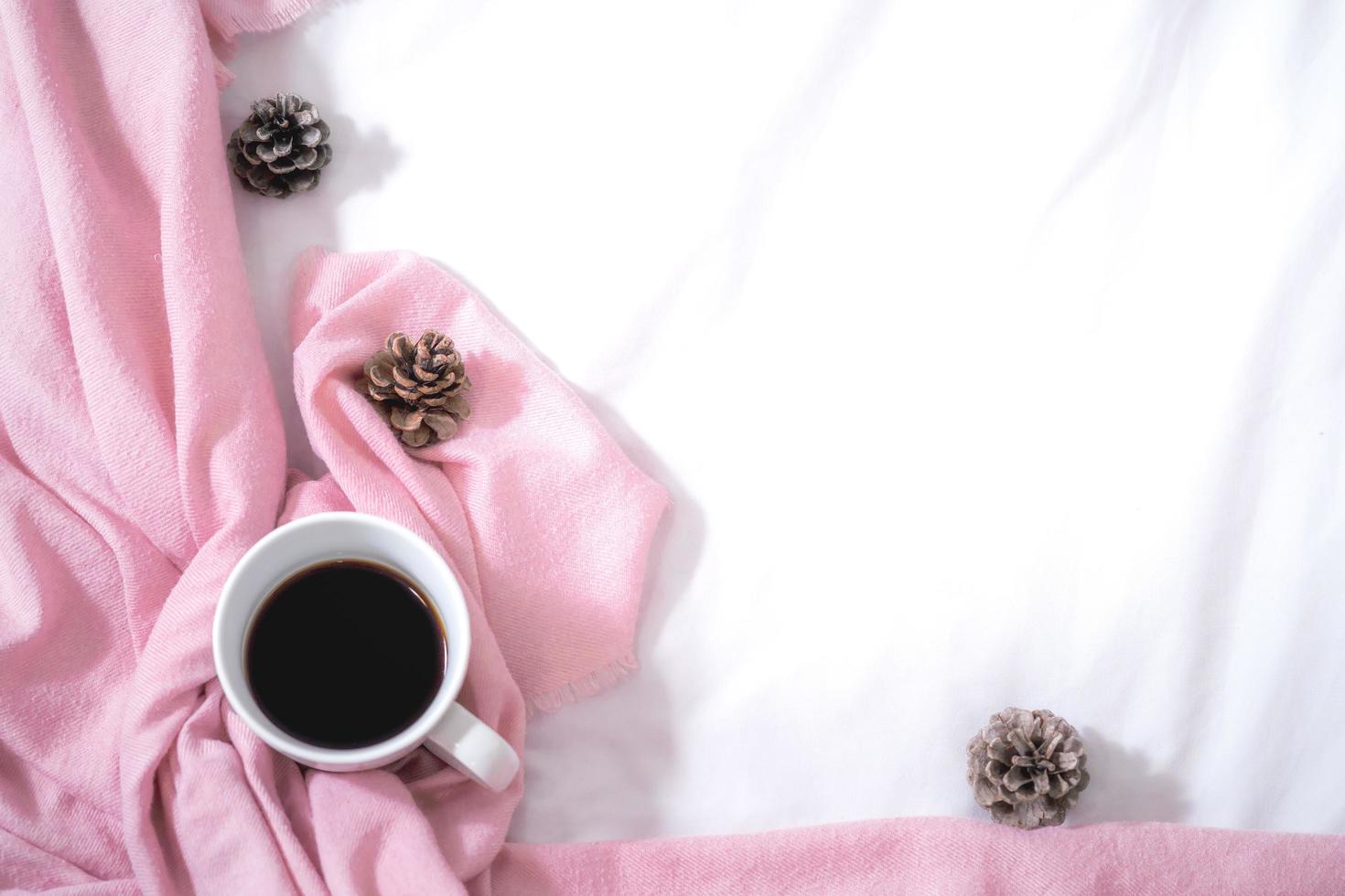 Christmas composition. Cup of coffee, scarf on pink background. Christmas, winter concept. Flat lay, top view, copy space photo