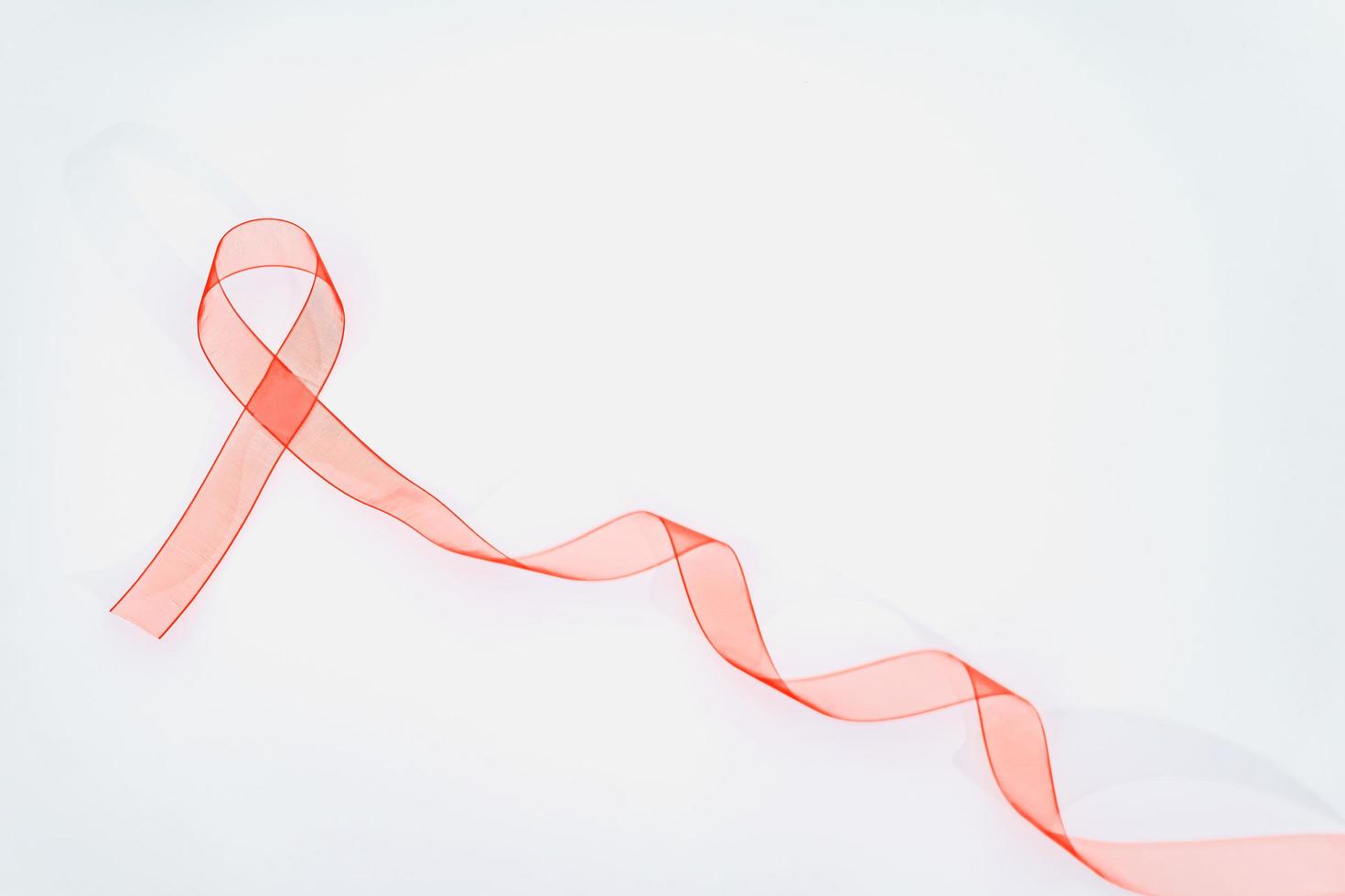 Closeup red ribbon awareness on White background for World Aids day campaign. Healthcare and medicine concept. photo