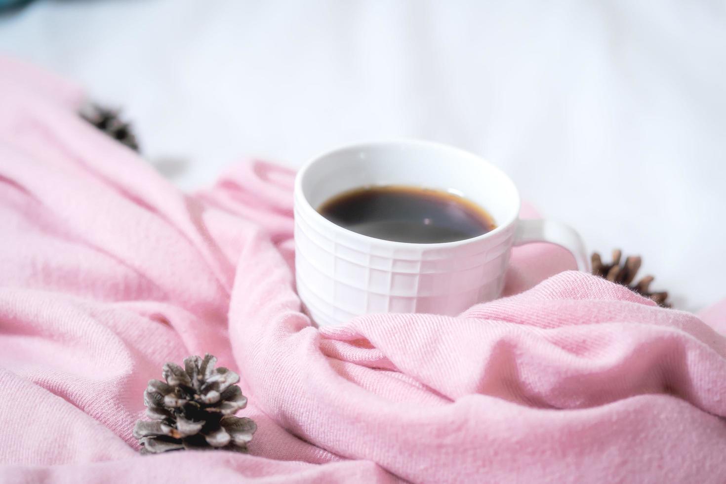 Christmas composition. Cup of coffee, scarf on pink background. Christmas, winter concept. Flat lay, top view, copy space photo