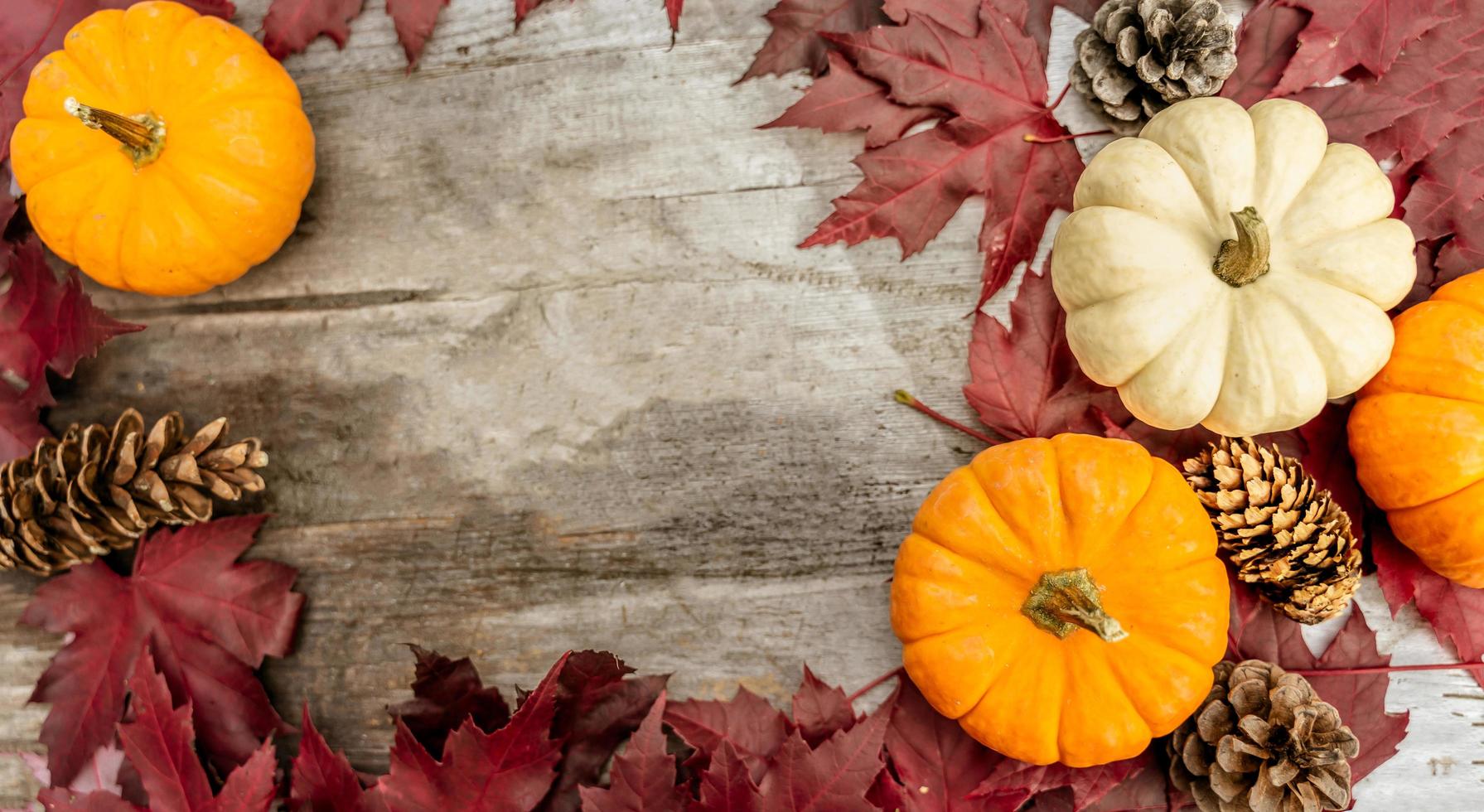 Festive autumn decor from pumpkins, pine and leaves on a  wooden background. Concept of Thanksgiving day or Halloween. Flat lay autumn composition with copy space. photo