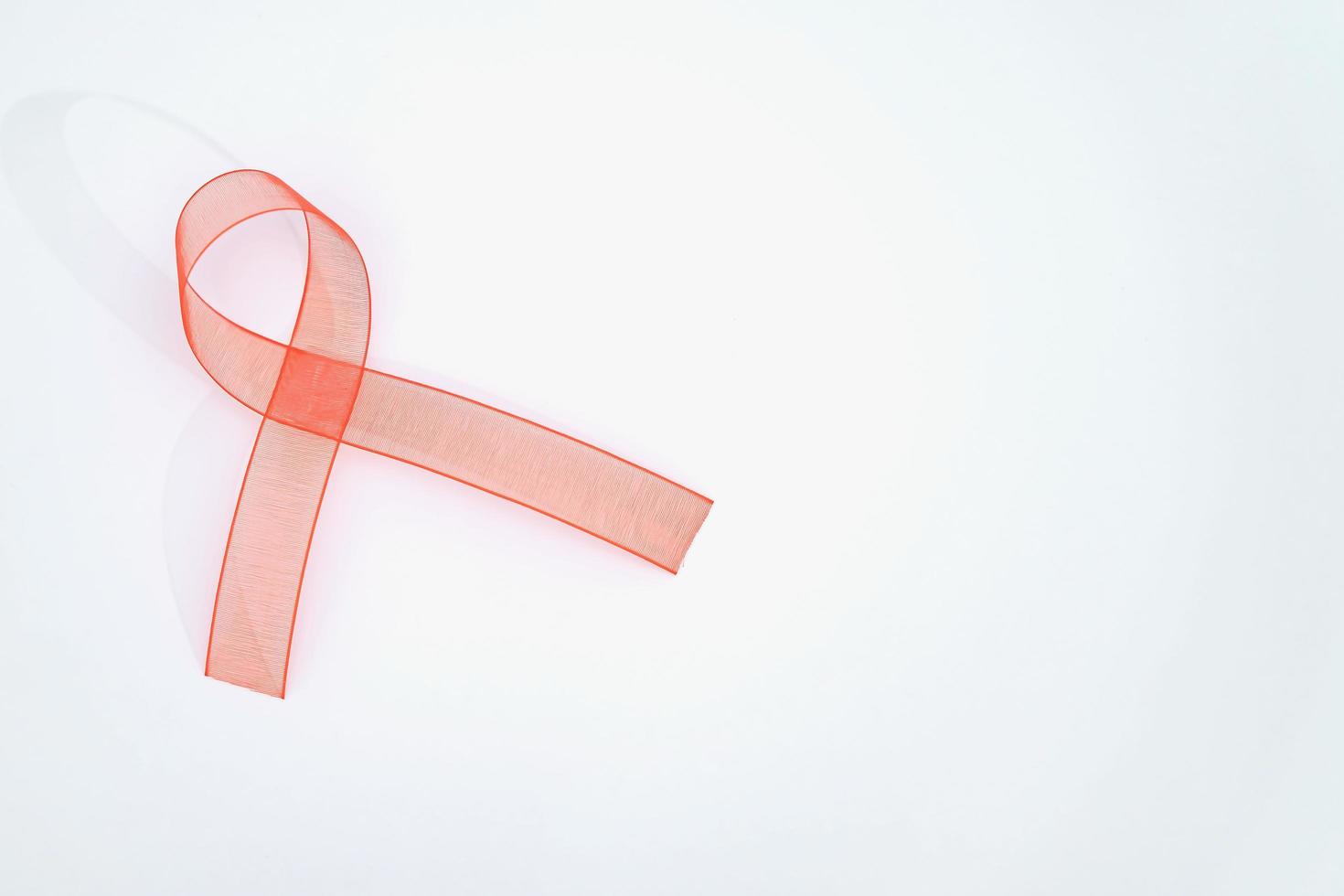 Closeup red ribbon awareness on White background for World Aids day campaign. Healthcare and medicine concept. photo