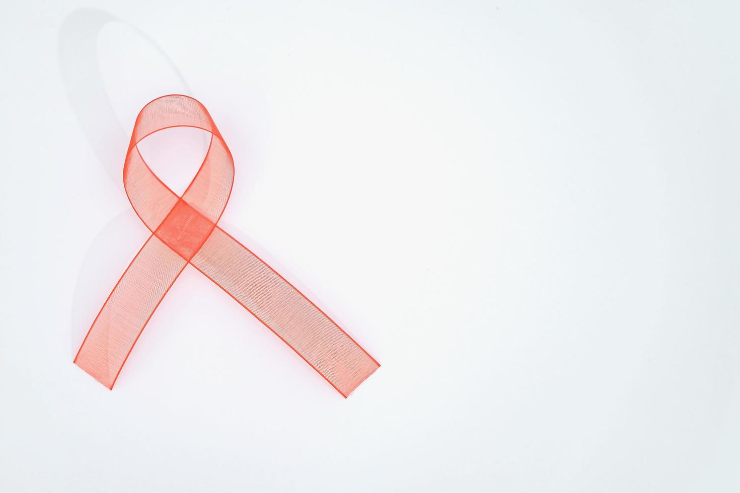 Closeup red ribbon awareness on White background for World Aids day campaign. Healthcare and medicine concept. photo