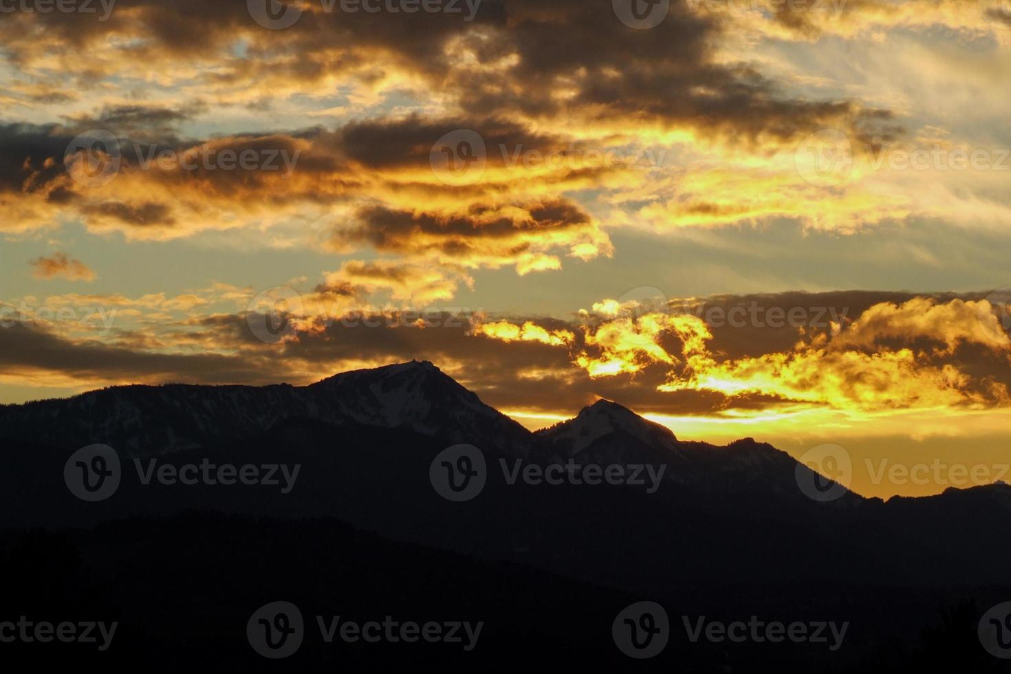 dramatic sky at sunset in the Chiemgau alps with Hochfelln and Hochgern photo