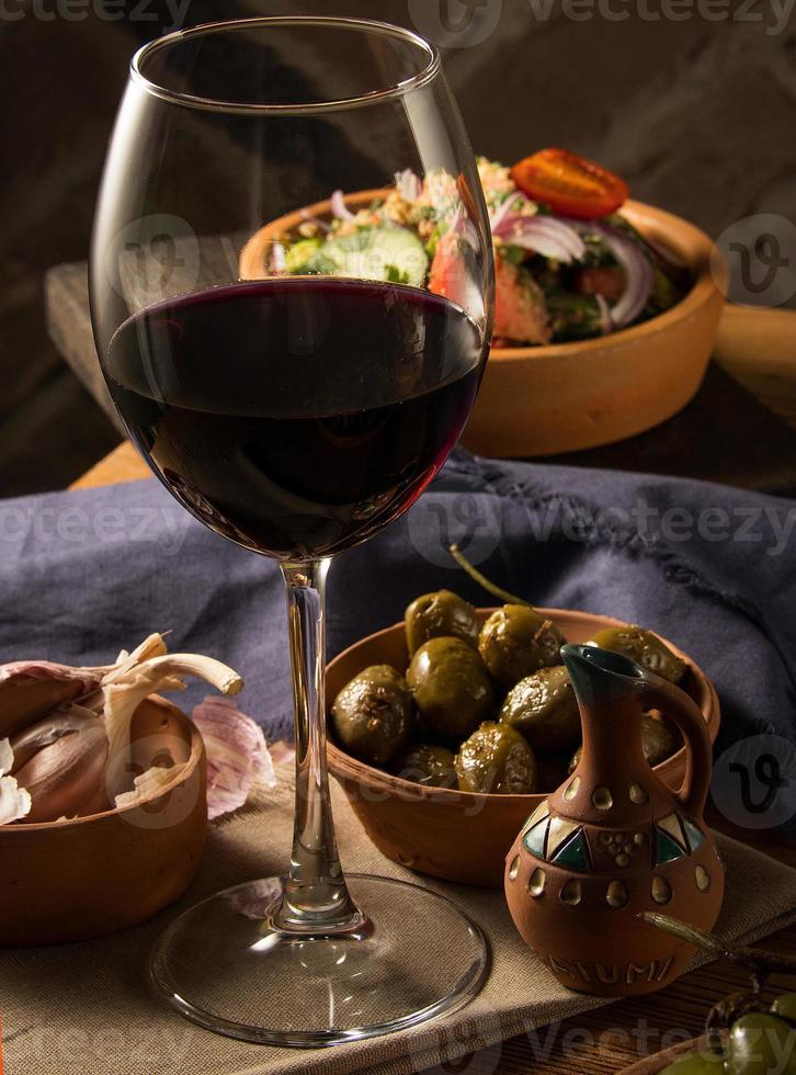 A glass of wine on a table with dishes photo