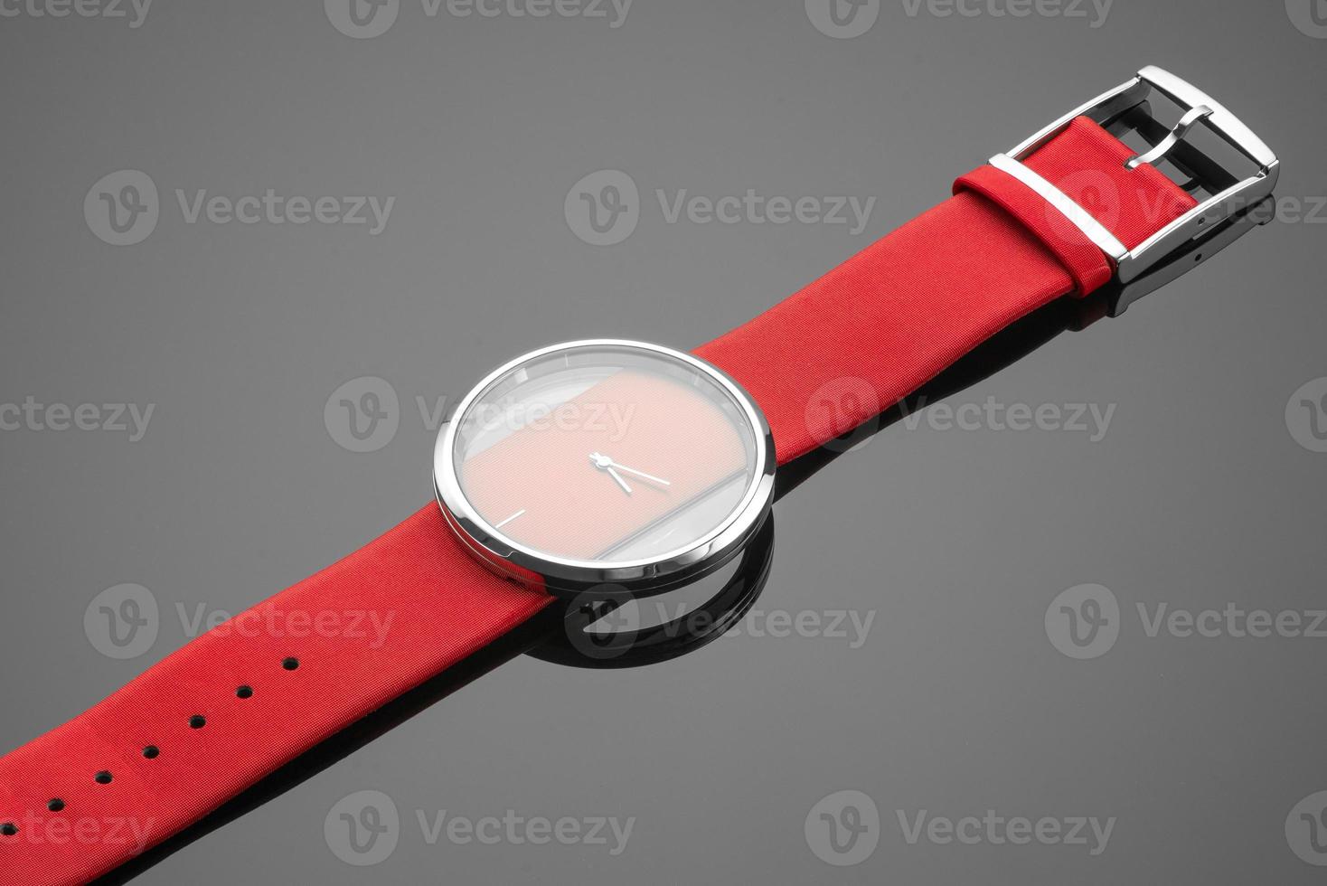 A close-up shot of a watch placed on a reflecting surface. photo