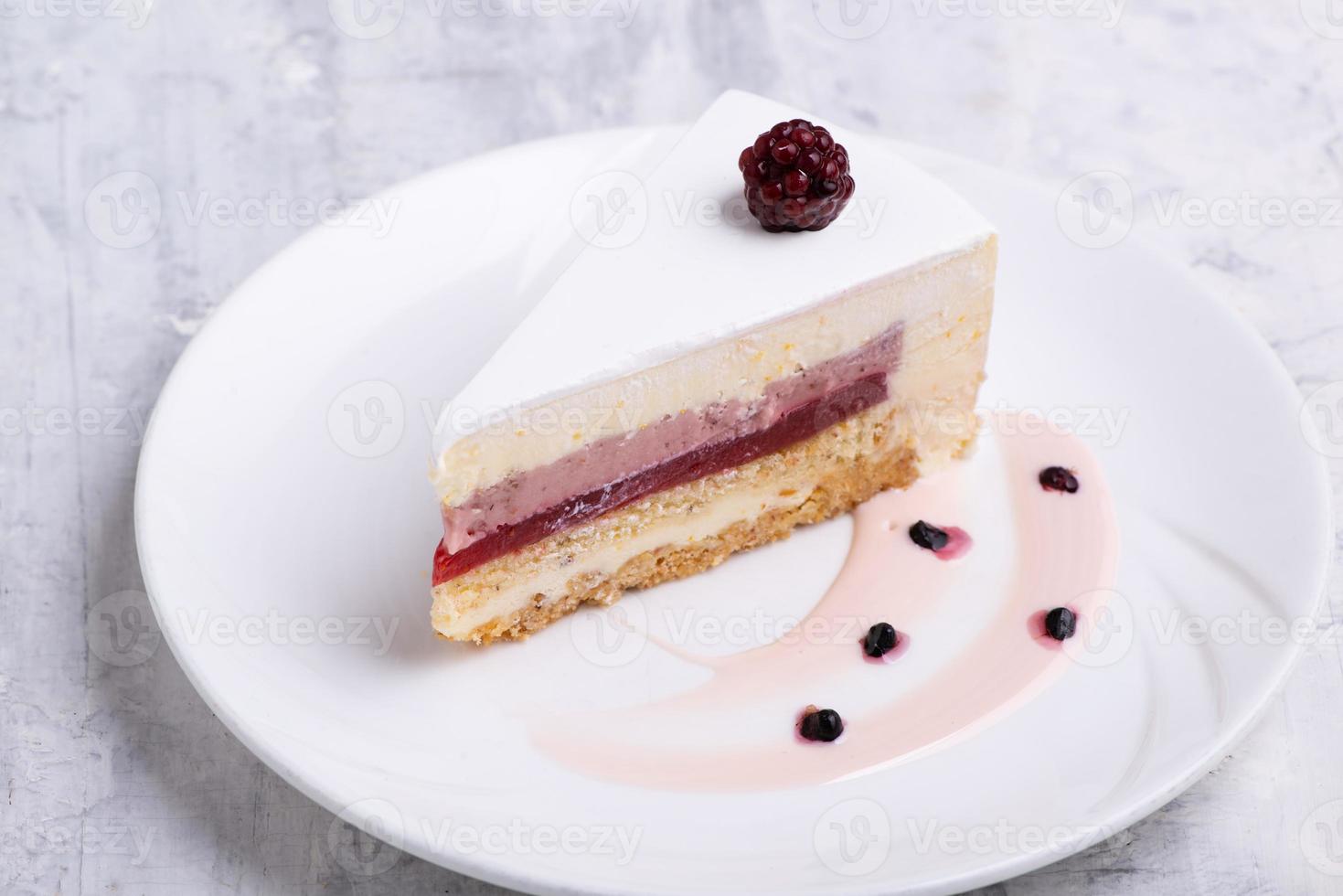 A closeup shot of white-layered cake topped with fresh berries photo