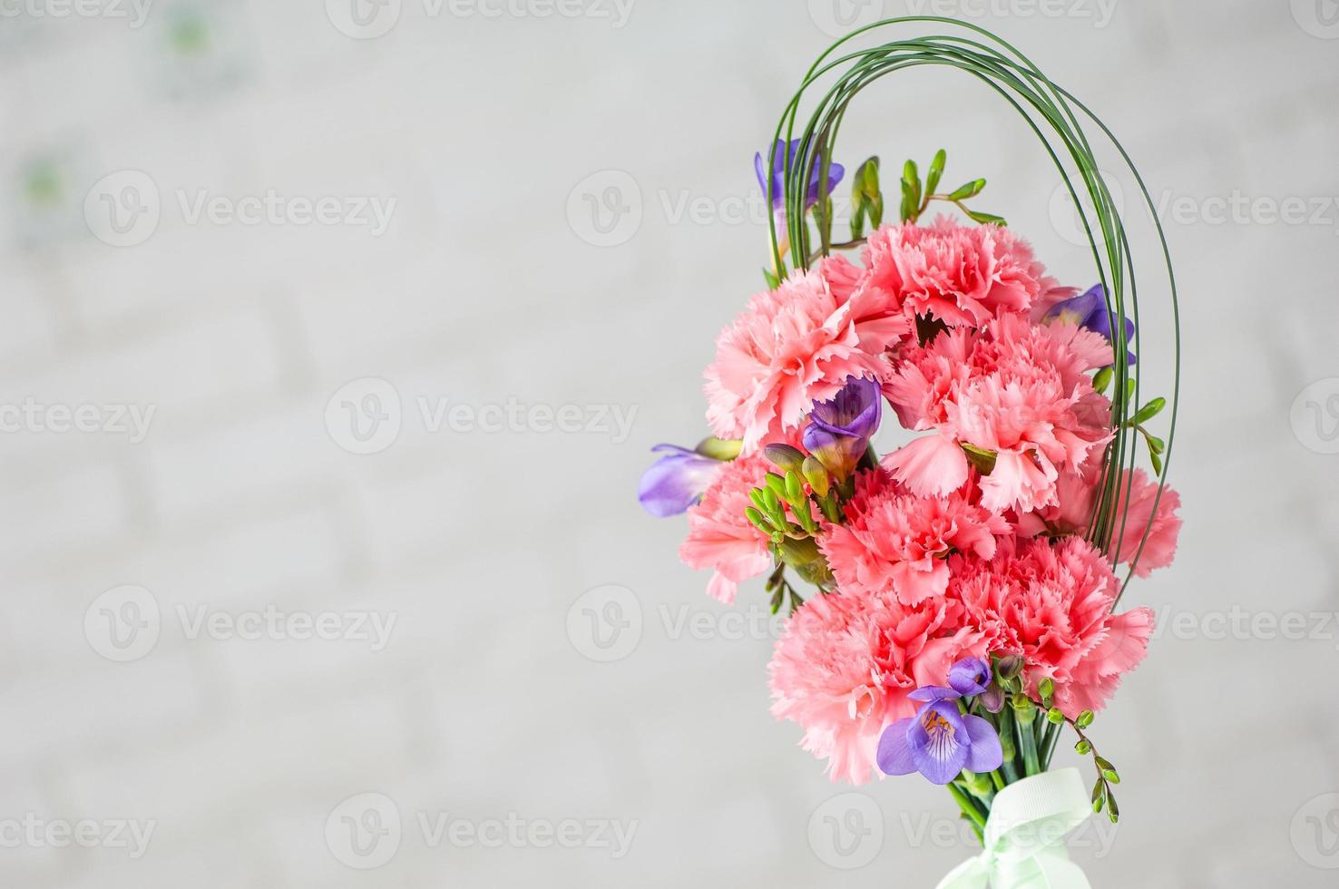 un primer plano de una hermosa composición con claveles de spray rosa y fresia aislado en un fondo blanco foto