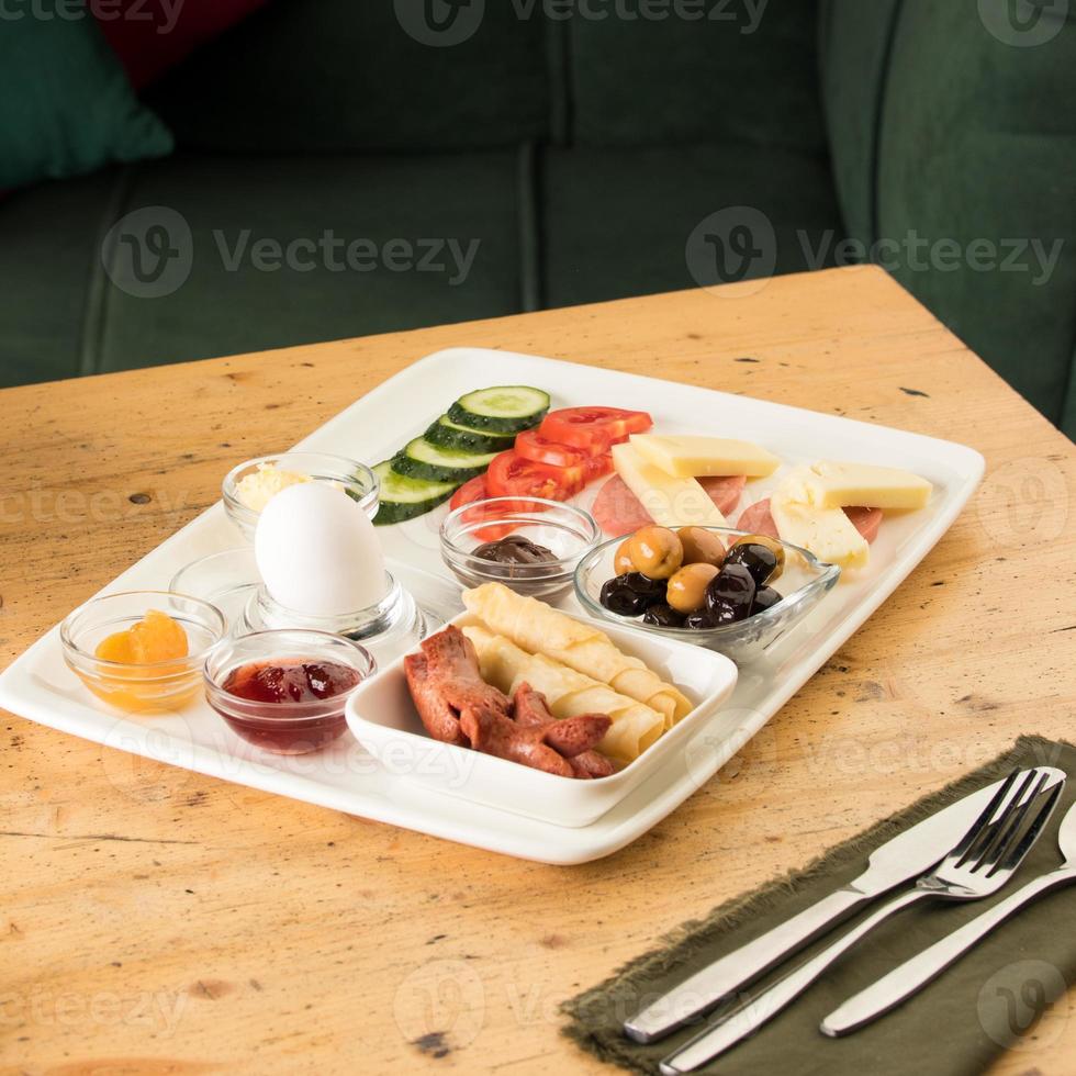 un primer plano de un plato blanco de desayuno en una mesa de madera foto