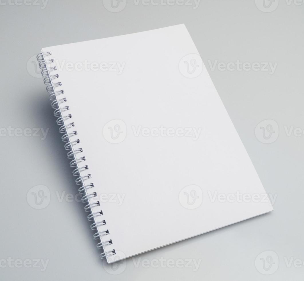 An angle shot of an open blank notebook on a white background with copy space. photo