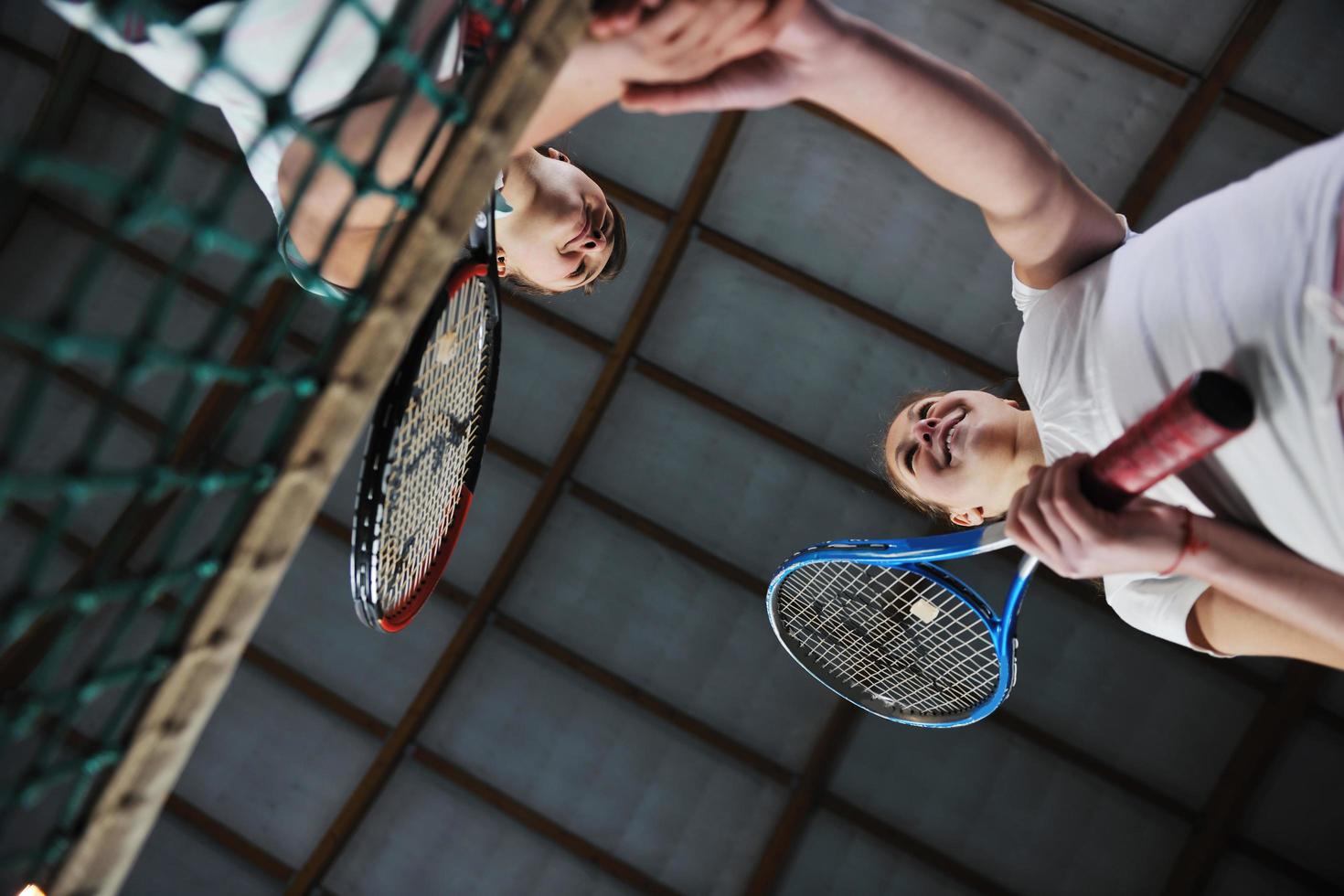 young girls playing tennis game indoor photo