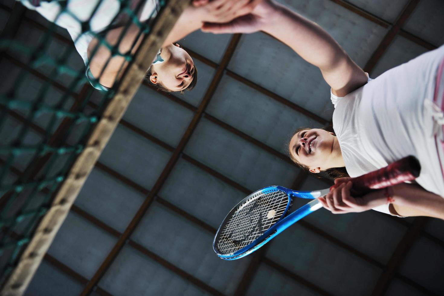 young girls playing tennis game indoor photo