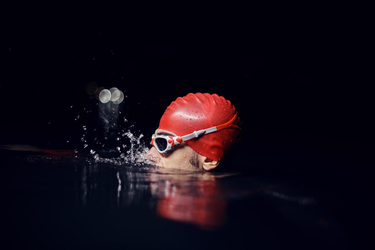 authentic triathlete swimmer having a break during hard training on night photo