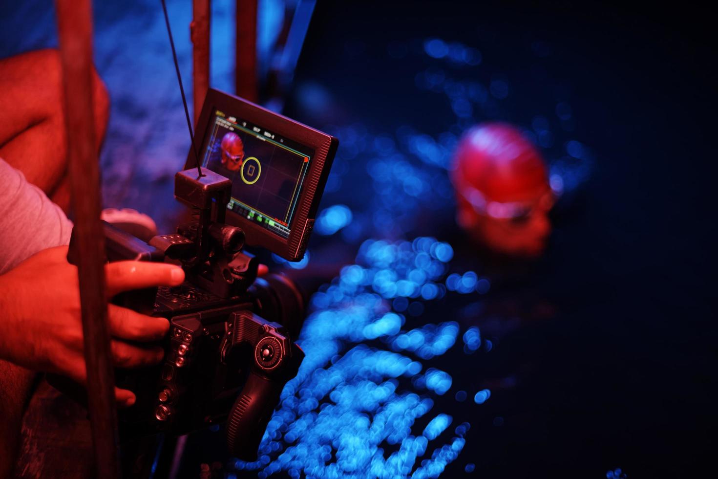 videographer  taking action shot of triathlon swimming athlete at night photo