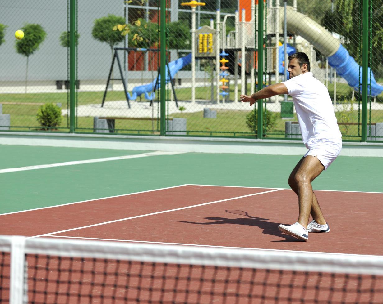 young man play tennis outdoor photo