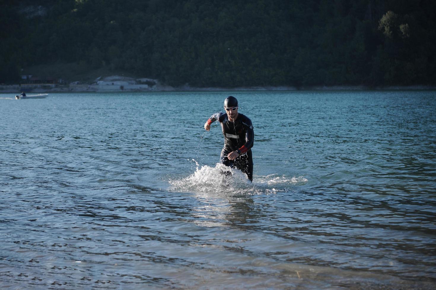 atleta de triatlón comenzando a nadar en el lago foto