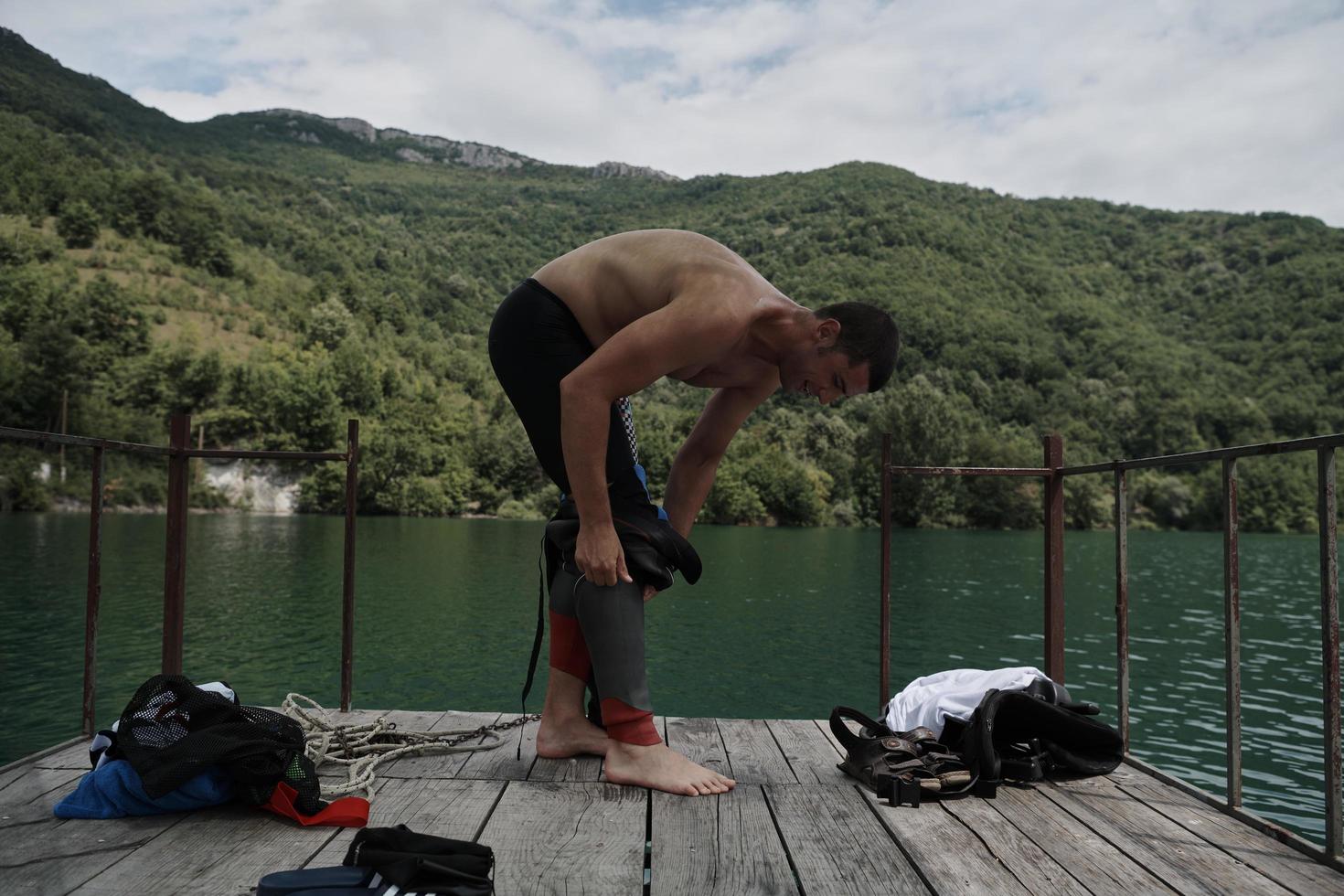 triathlon athlete getting ready for swimming training on lake photo