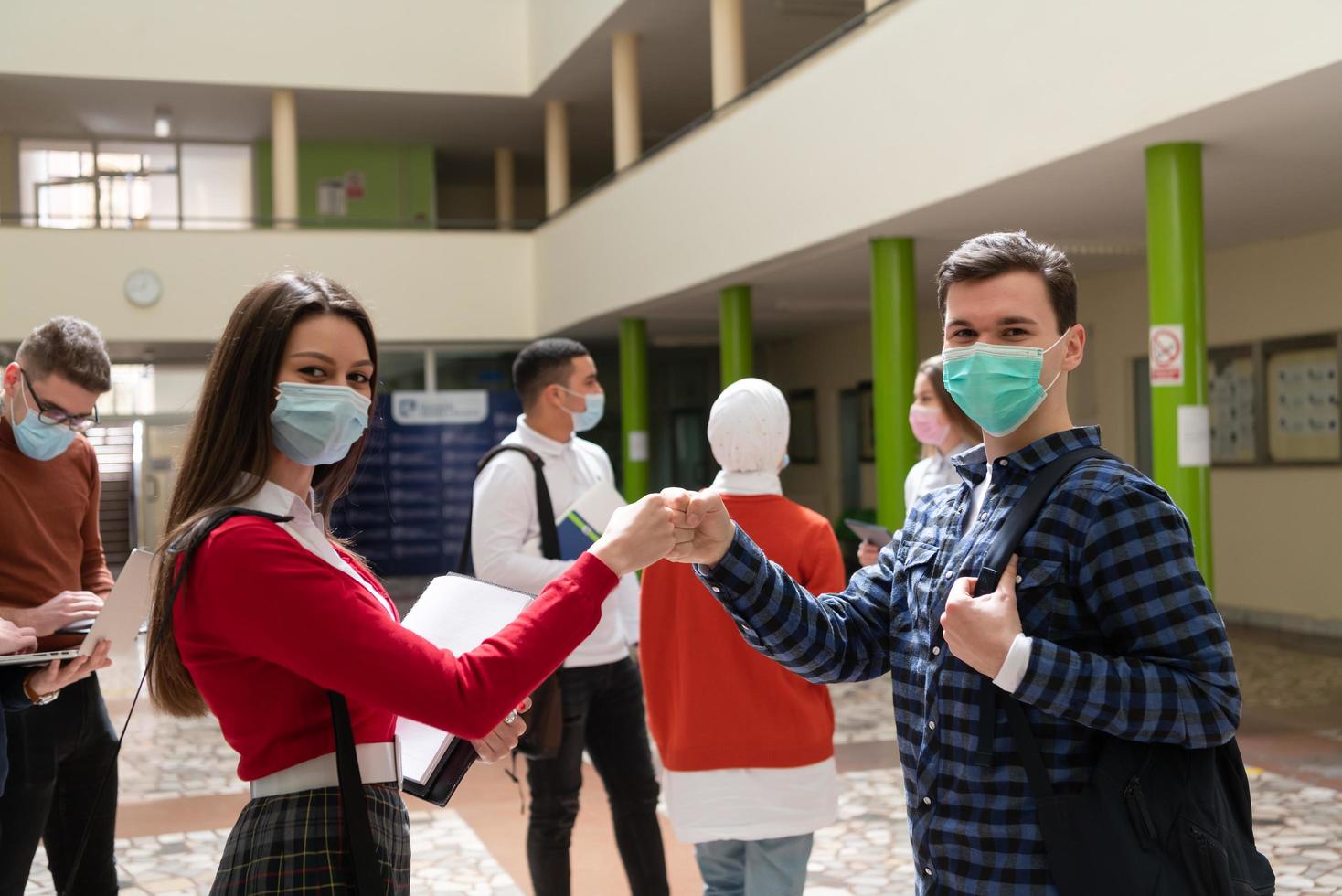 students greeting new normal coronavirus handshake and elbow bumping photo