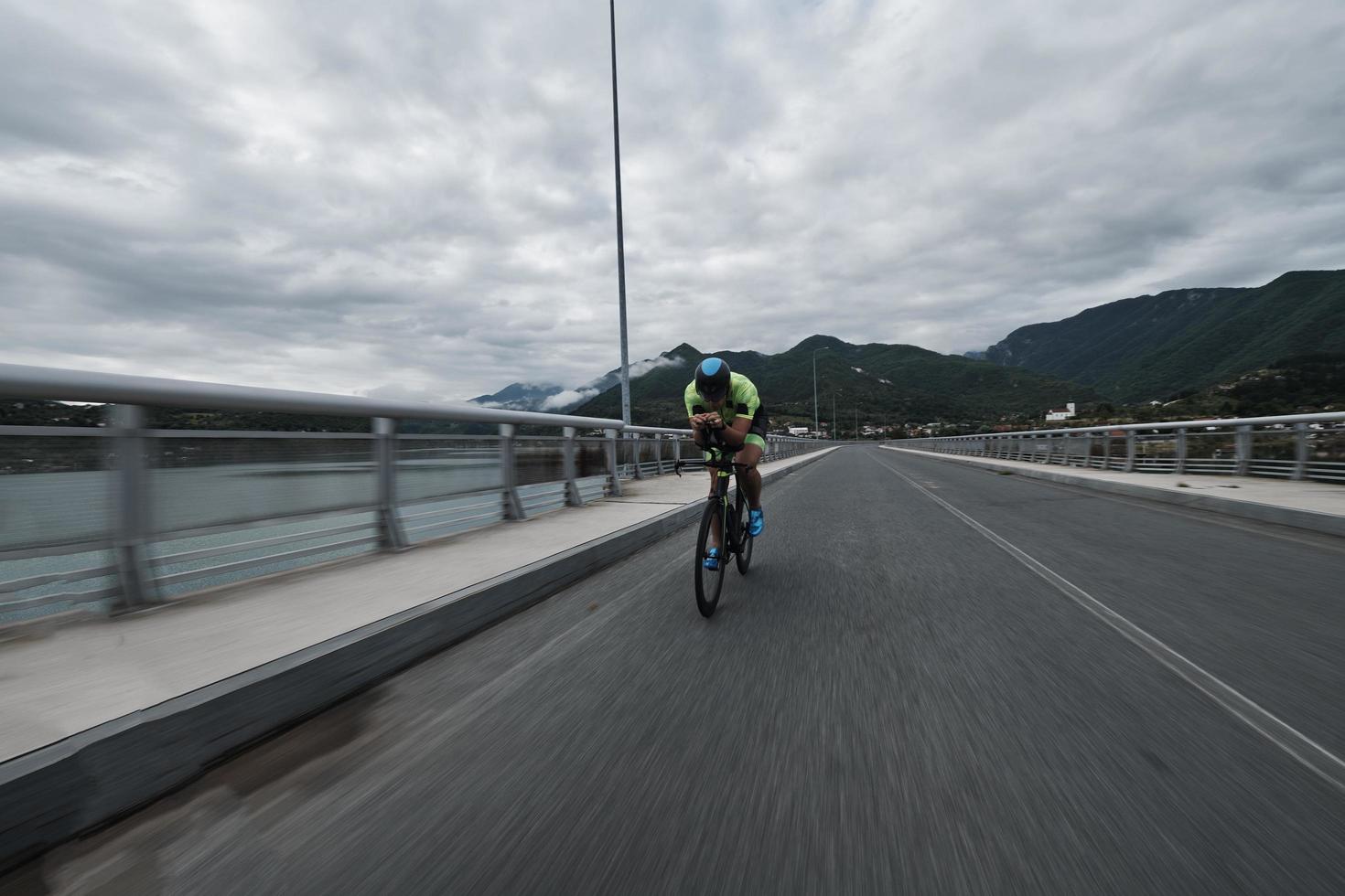 atleta de triatlón montando en bicicleta en el entrenamiento matutino foto