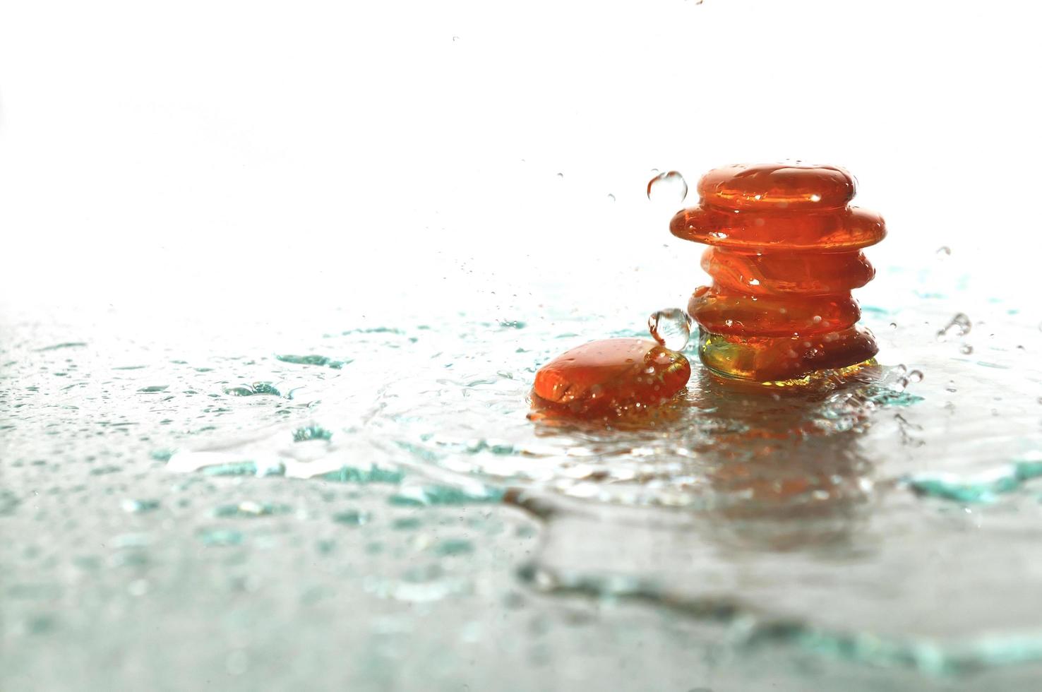 piedras zen húmedas aisladas con gotas de agua salpicadas foto