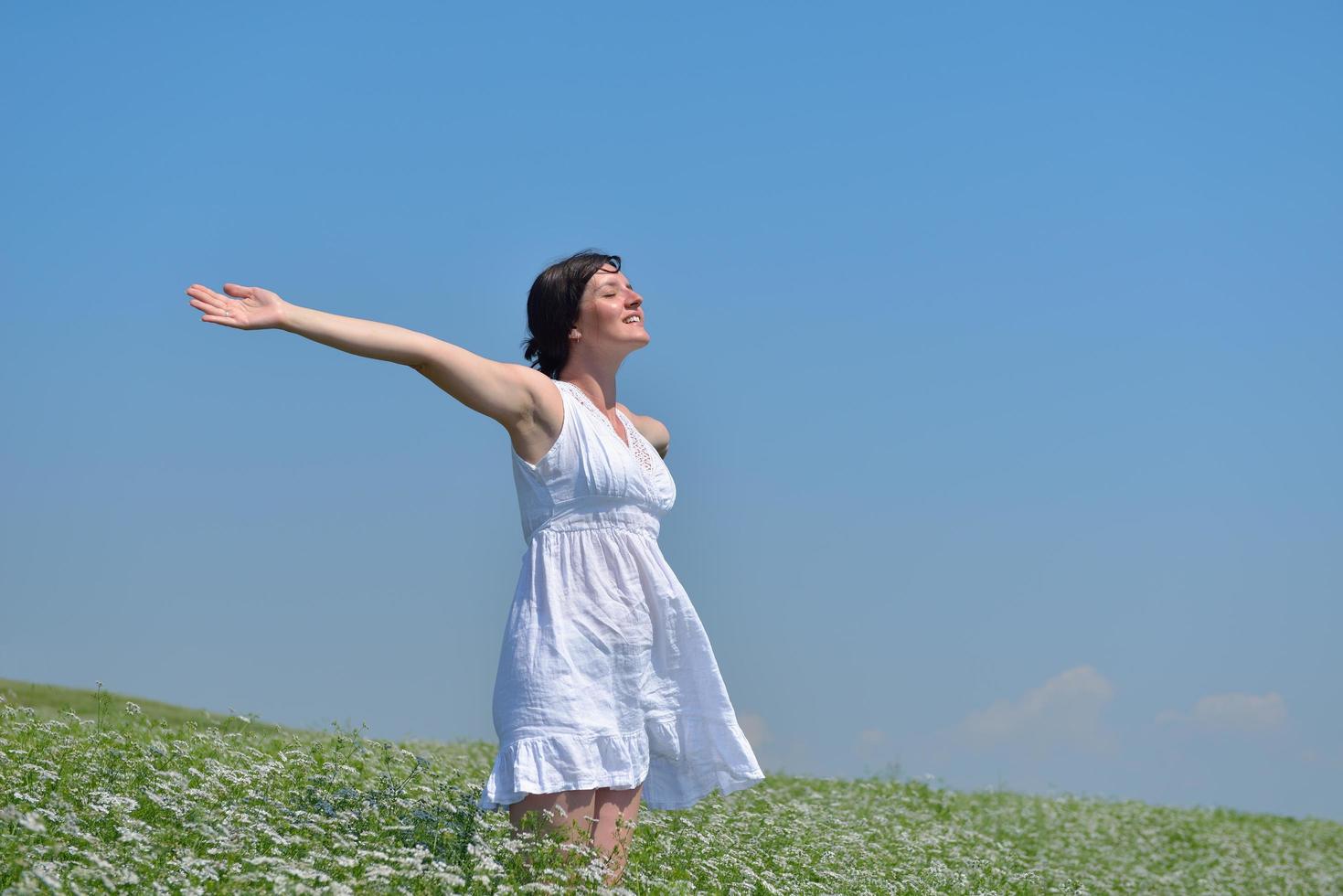 young woman with spreading arms to sky photo