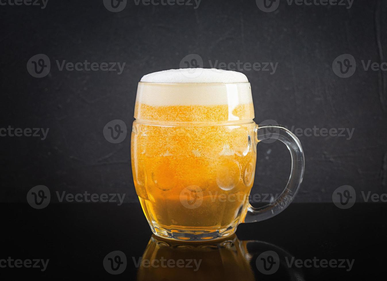 Mug of light beer on dark background. Craft unfiltered beer photo