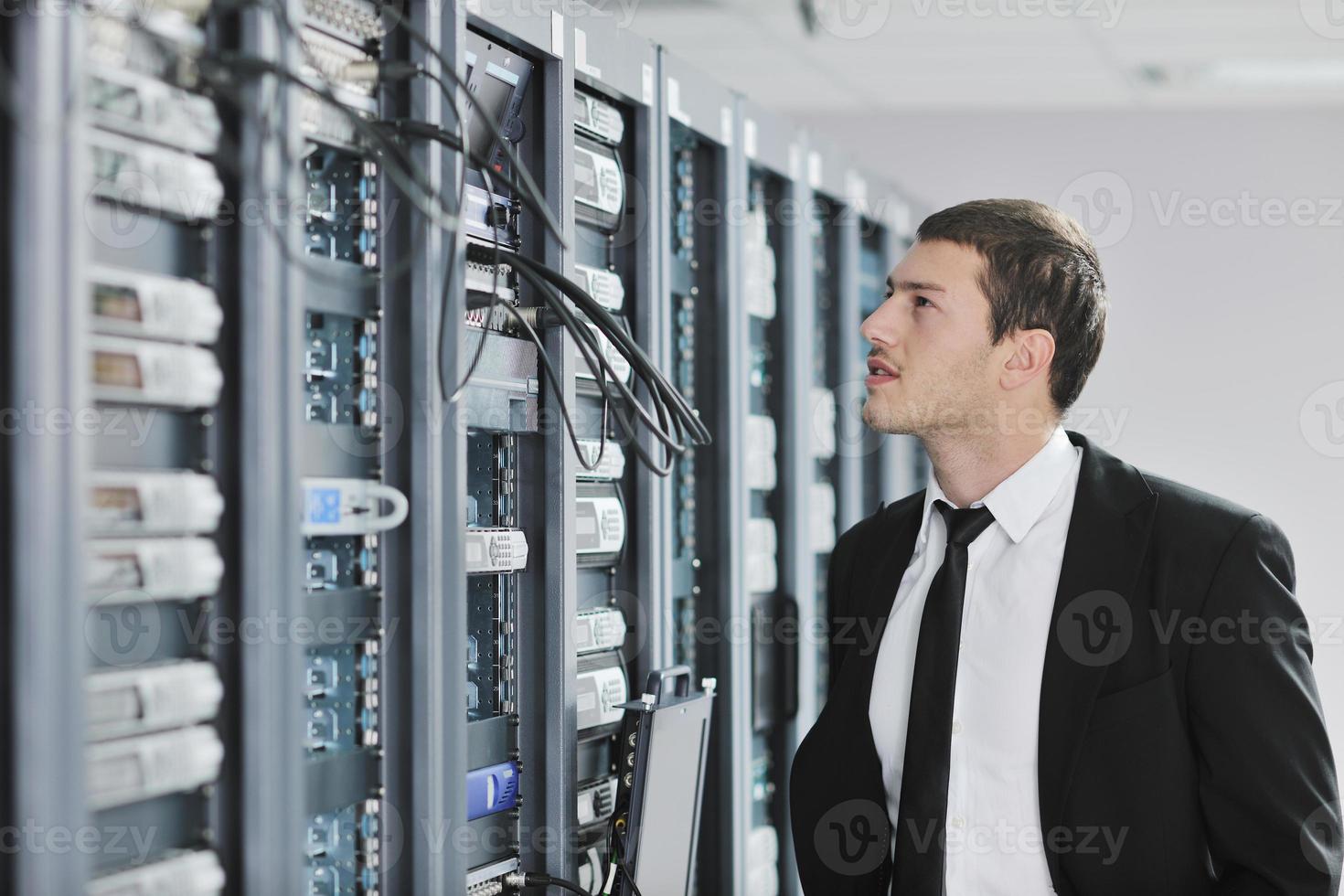 young engeneer in datacenter server room photo