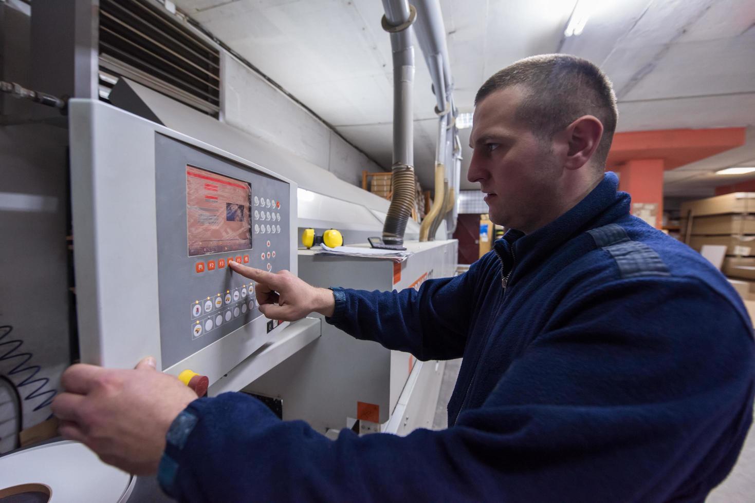 carpenter calculating and programming a cnc wood working machine photo