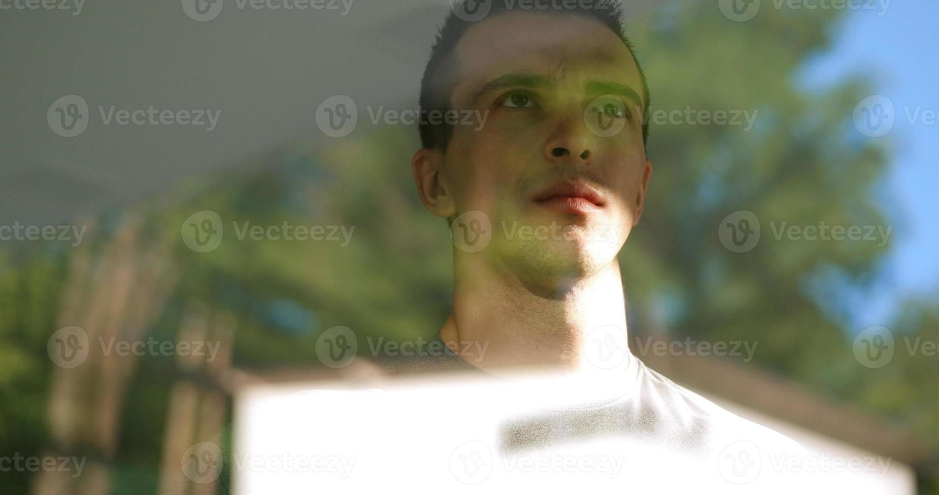 reflection of sad man looking through window photo