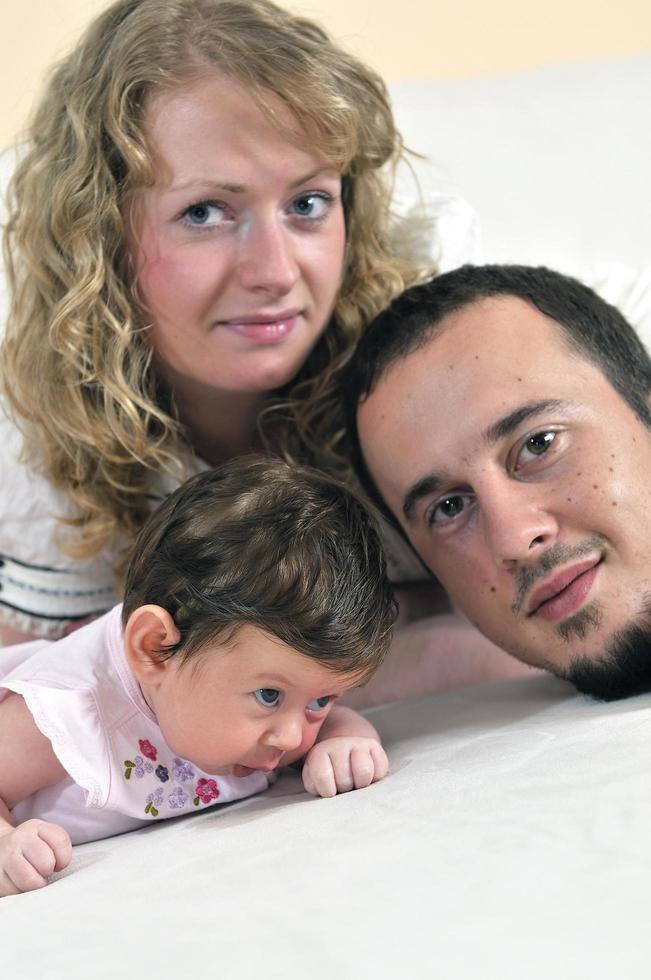retrato interior con una familia joven feliz y un lindo bebé foto