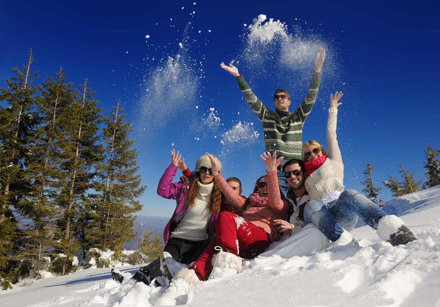 los amigos se divierten en invierno con nieve fresca foto