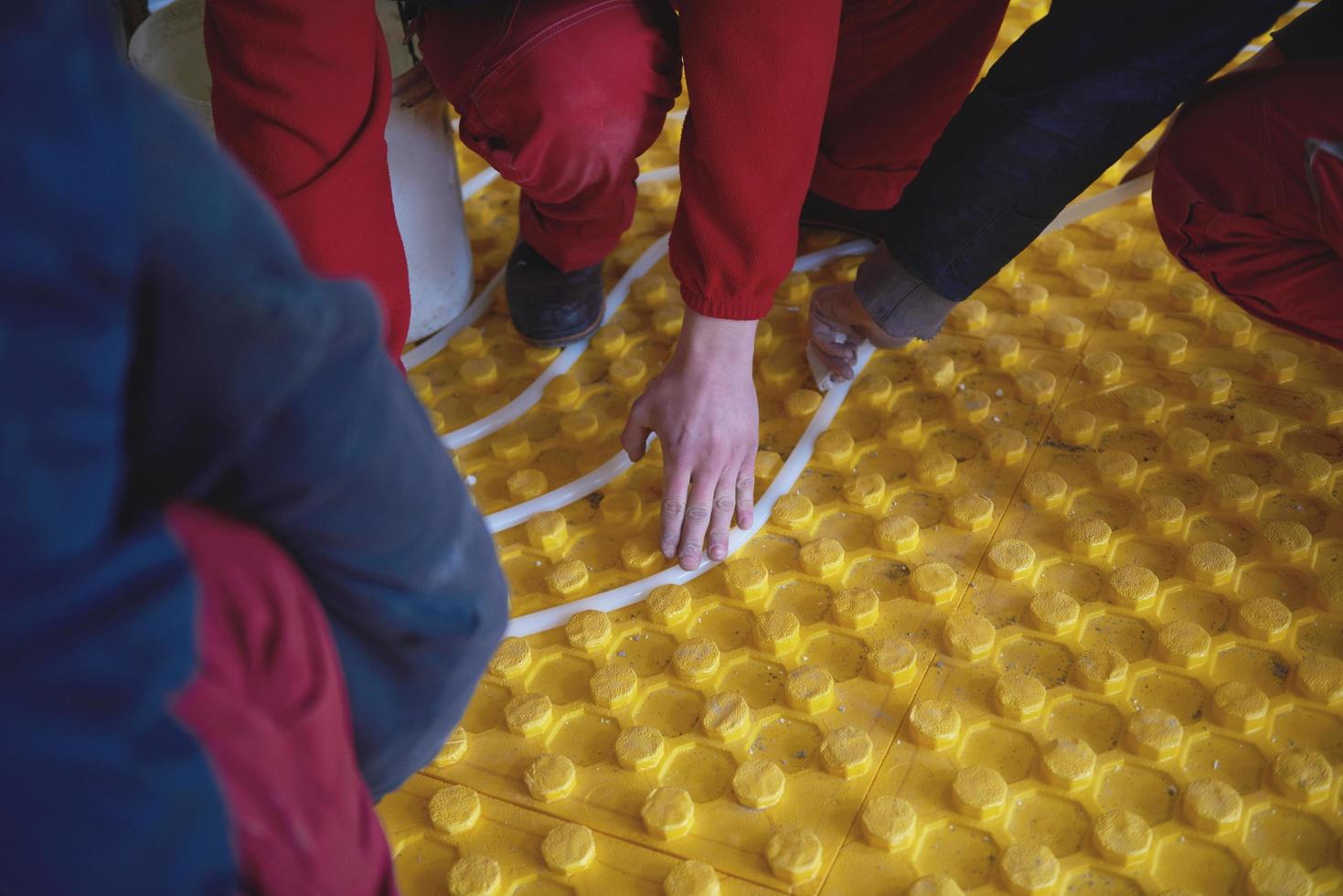workers installing underfloor heating system photo