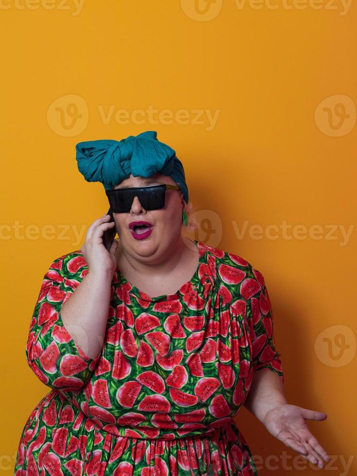 Blonde plus size woman having conversation talking by smartphone over yellow background smiling with an idea or question pointing finger with happy face, number one photo