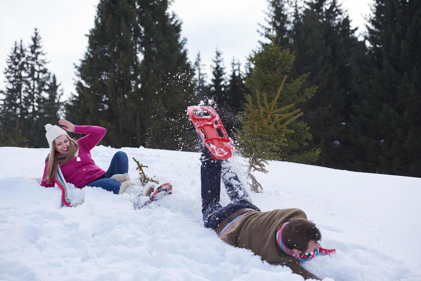 couple having fun and walking in snow shoes photo