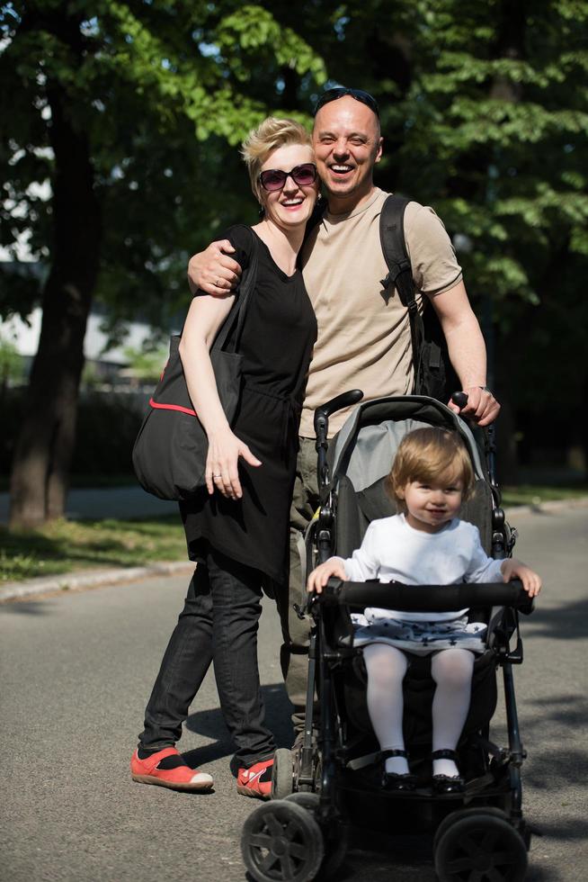 couple with baby pram in summer park photo