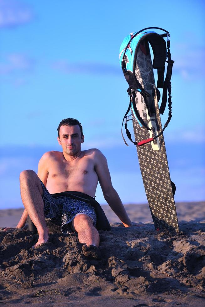Portrait of a young  kitsurf  man at beach on sunset photo