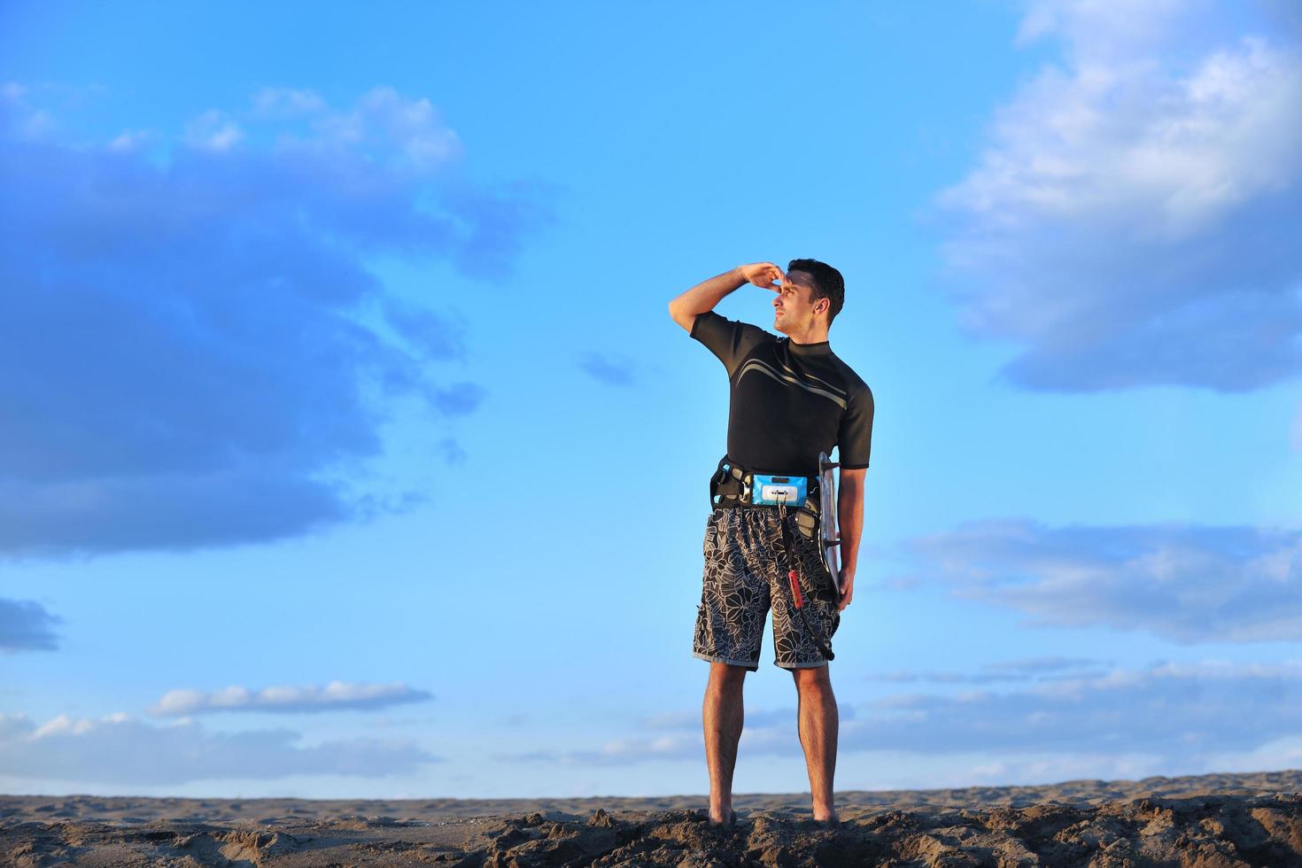 Portrait of a young  kitsurf  man at beach on sunset photo