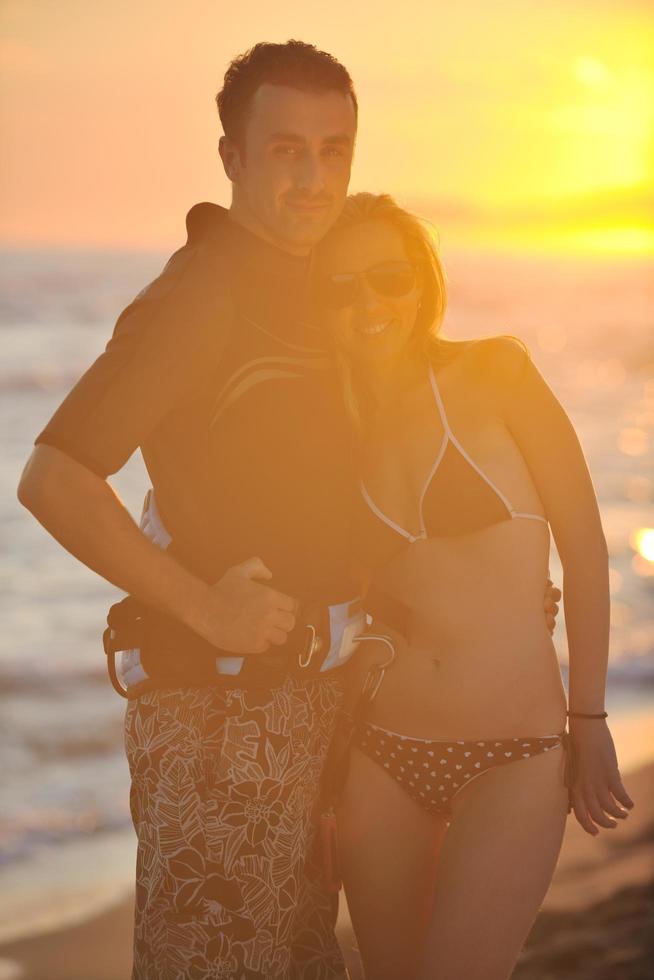 surf couple posing at beach on sunset photo