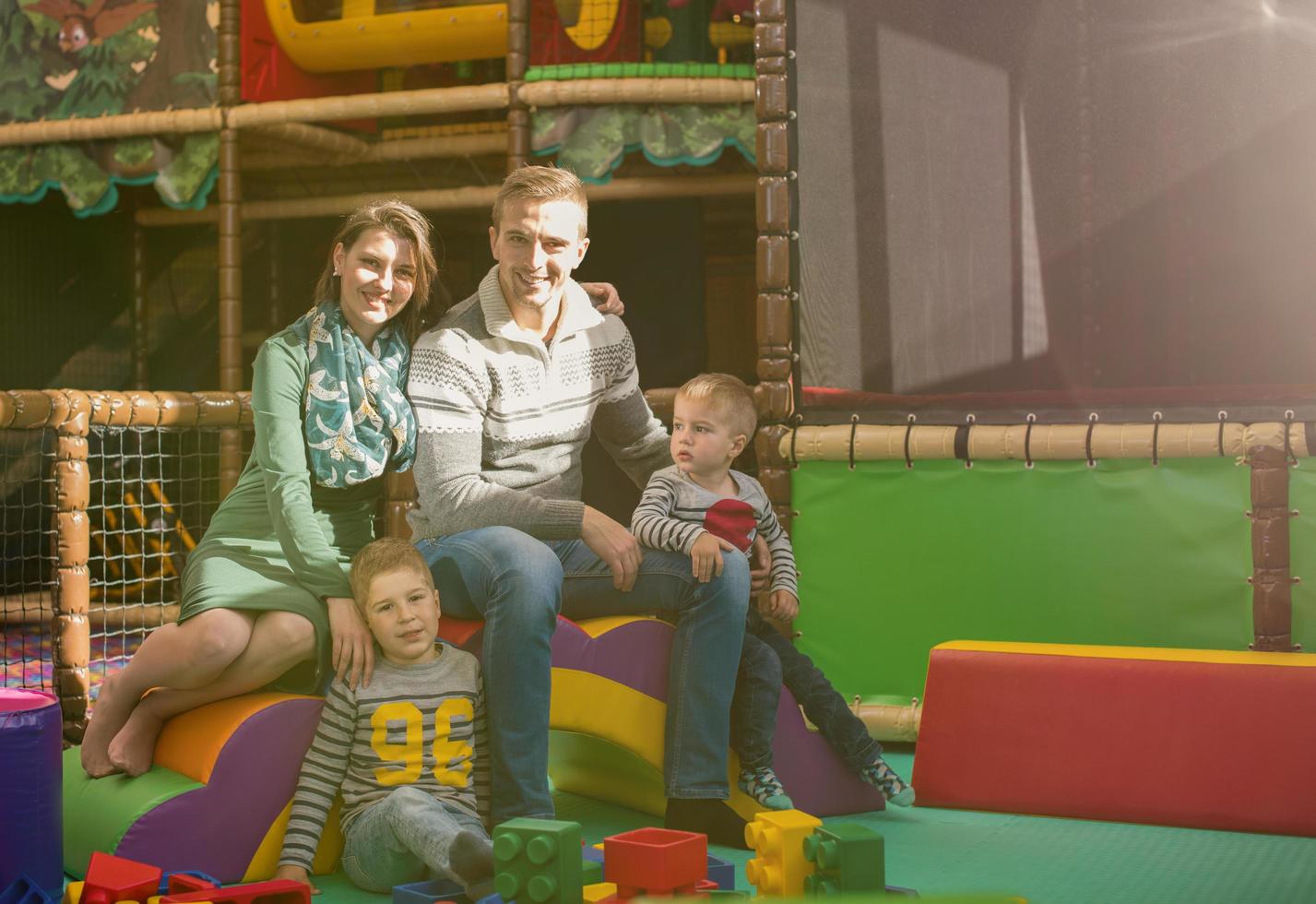 young parents and kids having fun at childrens playroom photo