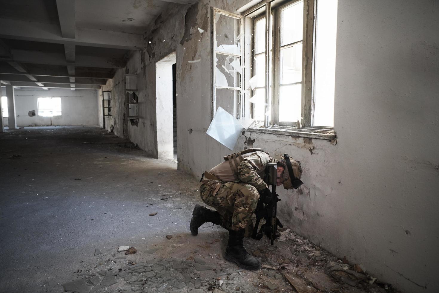 soldier in action near window changing magazine and take cover photo