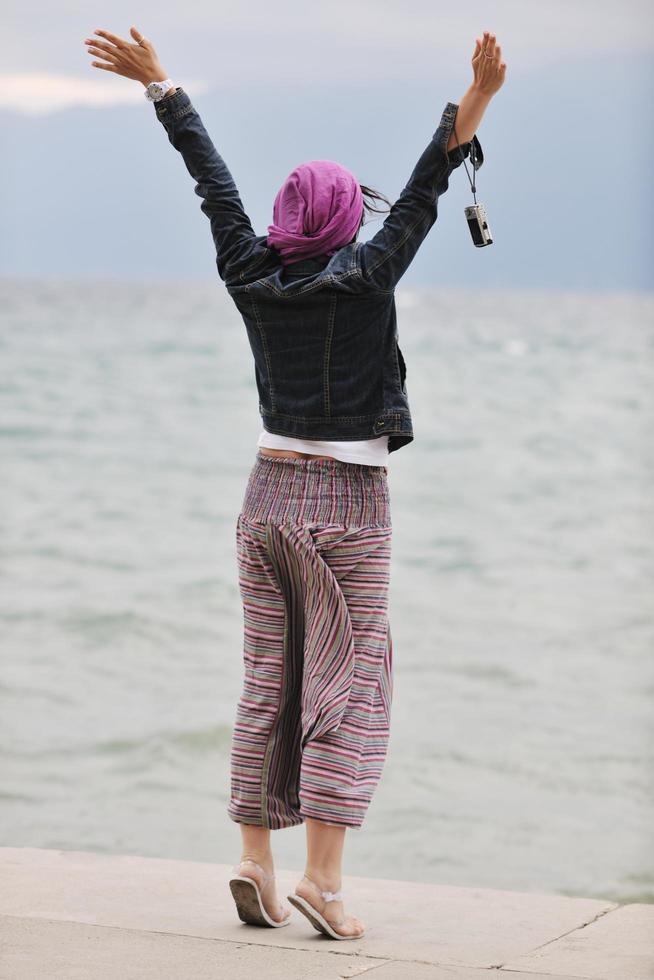 hermosa mujer joven en la playa con bufanda foto